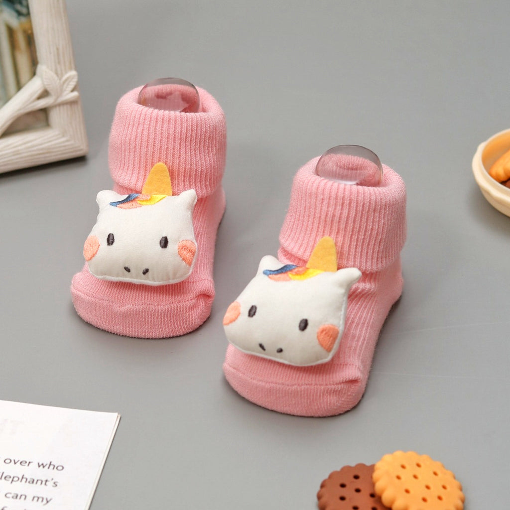 Cute pink unicorn stuffed toy socks for baby girls on display