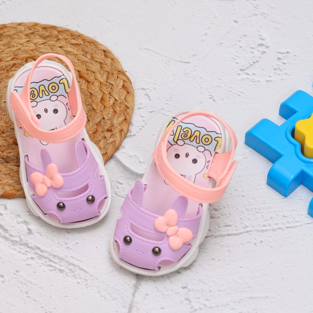 Adorable toddler sandals with purple bunny applique and peach straps on a playful background.
