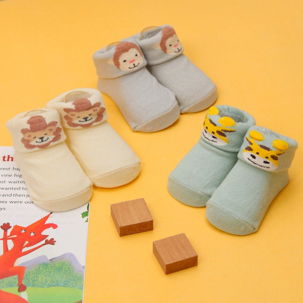 Baby girl's anti-skid socks with a charming yellow giraffe design on a pastel background.