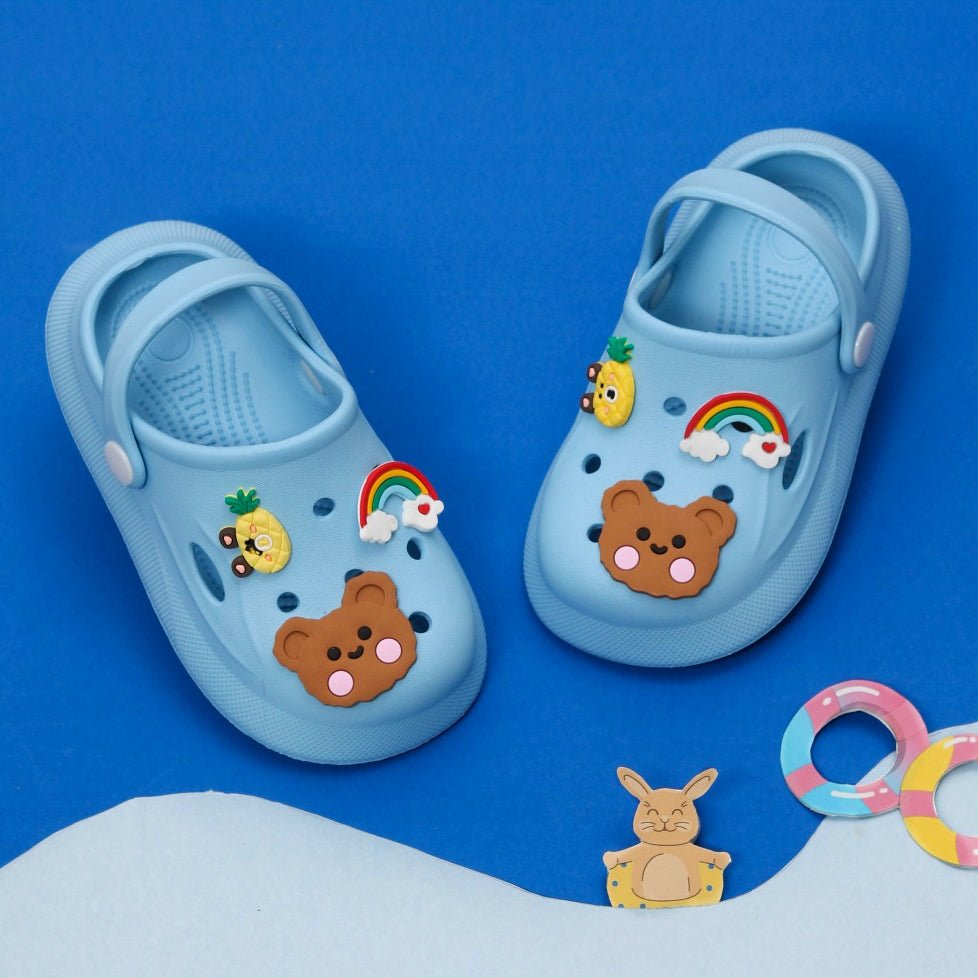 Pair of blue clogs on a vibrant blue background, perfect for kids.