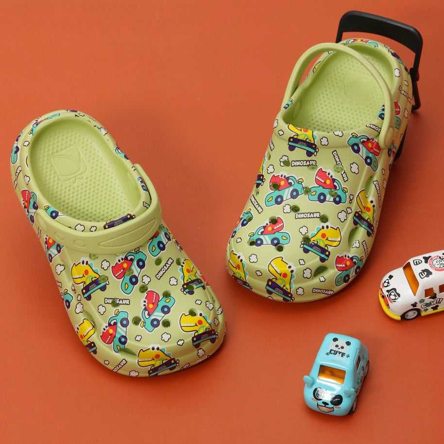 "Dino Racers" Green Car Print Clogs for boys by Yellow Bee on a playful backdrop.