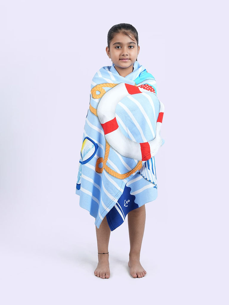 Young girl wrapped in Yellow Bee's blue and white summer towel, depicting size and comfort.