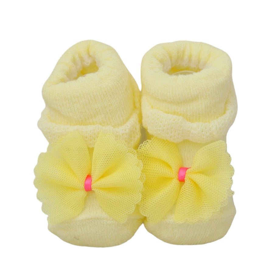 Pair of yellow baby girl socks adorned with delicate bow accents.