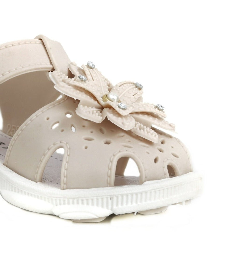 Close-up of the flower detail on a beige sandal for kids