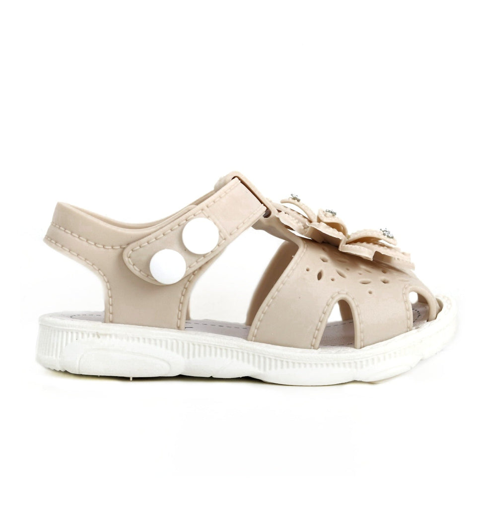 Side view of a child's beige sandal with floral embellishment and cushioned sole.