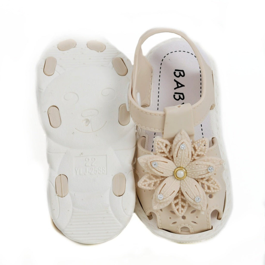 Top and sole view of children's beige sandals with flower decorations.