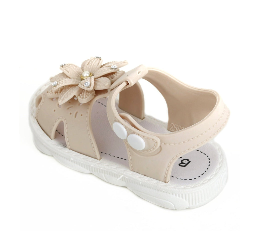 Child's beige flower-embellished sandal angled to display the top and side.