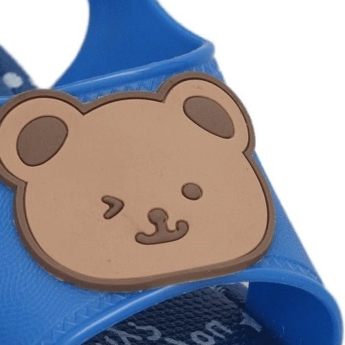 Close-up of the bear applique on a blue children's sandal.