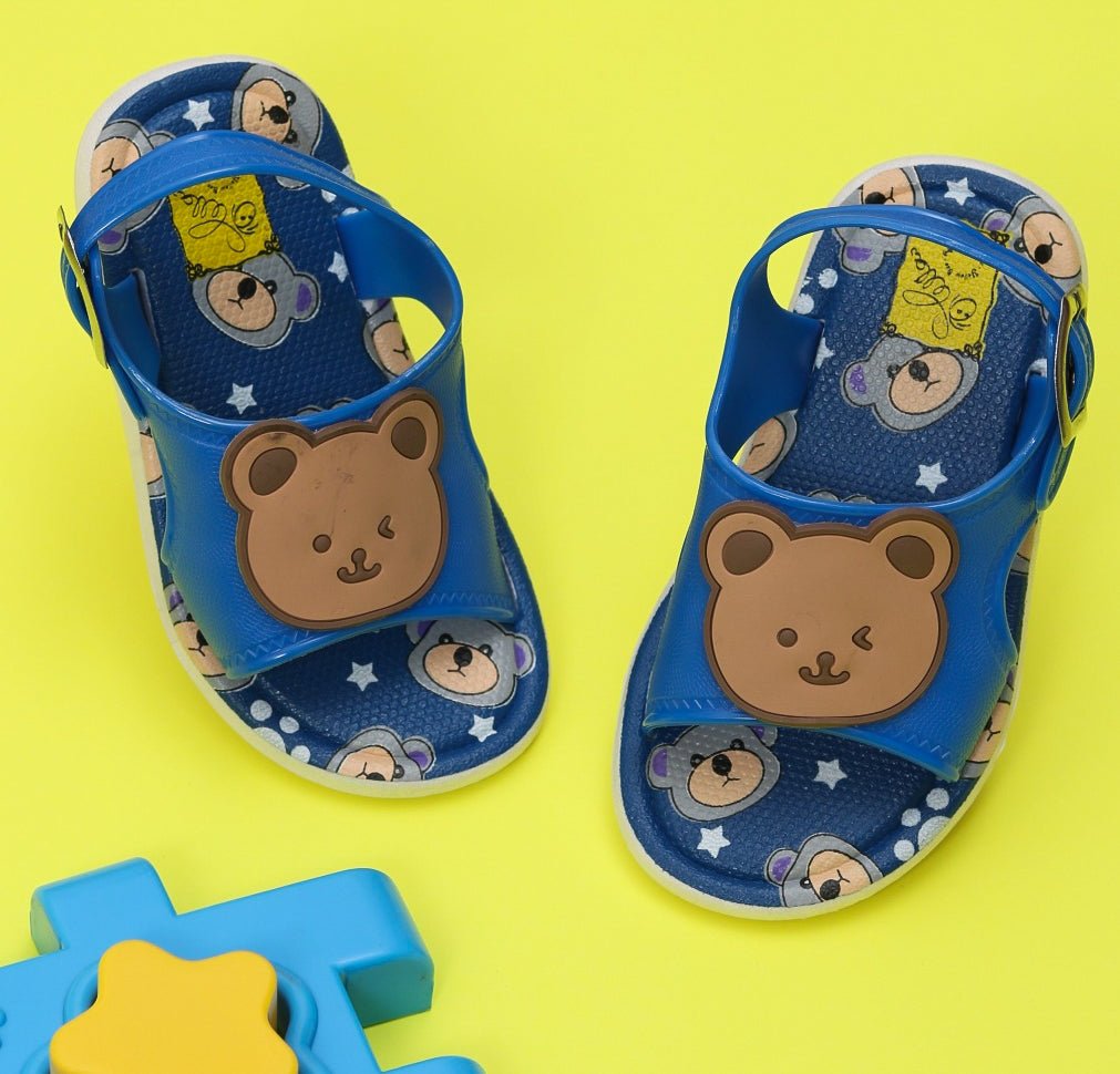 Vibrant blue children's sandals with bear applique on a yellow background.