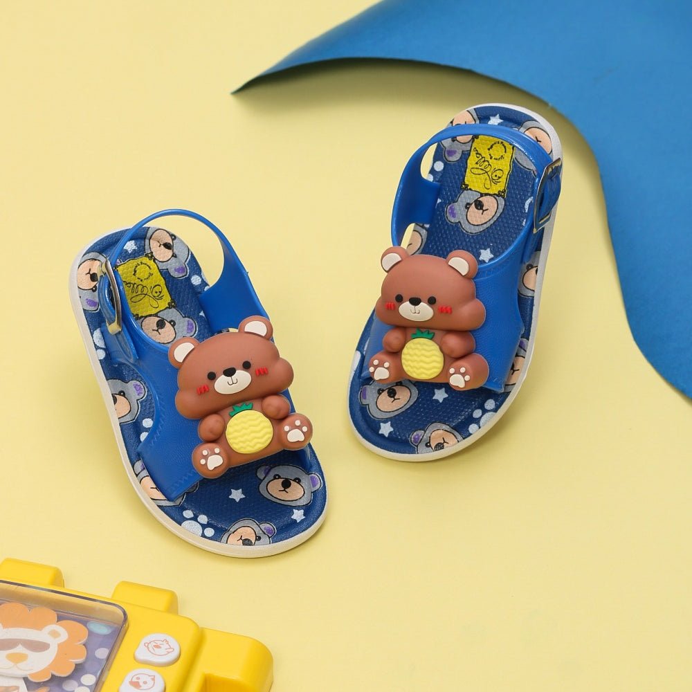 Adorable kids' Blue Teddy Applique Sandals displayed on a yellow background with playful accessories nearby