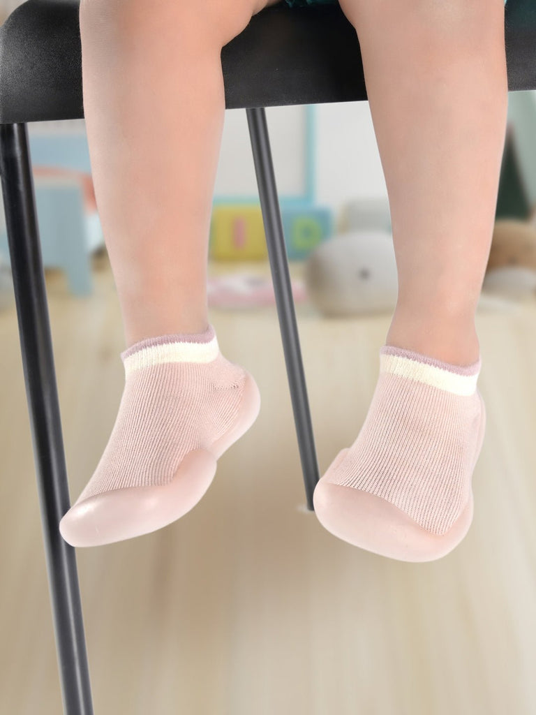Toddler's feet in Pink Solid Shoe Socks by Yellow Bee, ideal for play and comfort