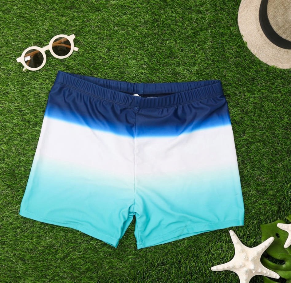Boys' Striped and Star Print Swim Shorts by Yellow Bee on grass with summer accessories.