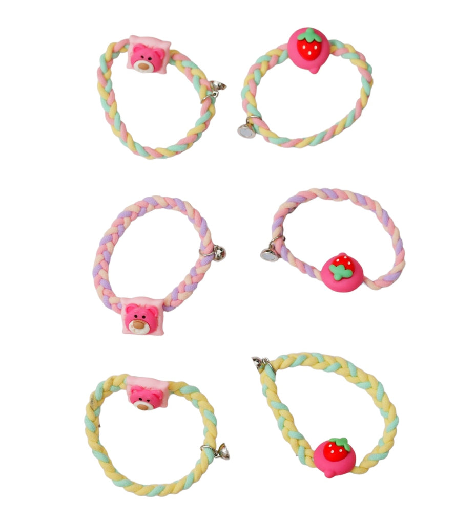 Assorted braided rubber bands by Yellow Bee, each with a bear or strawberry charm and a magnet, arrayed against a vibrant background.
