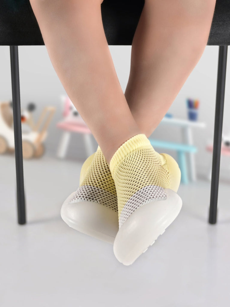 Child sitting with Yellow Bee's Breathable Shoe Socks in casual setting