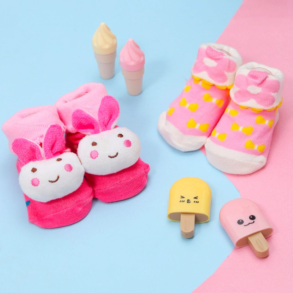 Adorable baby girl socks with rabbit face and ears on a colorful background with toy ice cream.