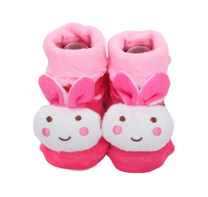 Pair of baby girl socks with pink bunny design and ears on white background.