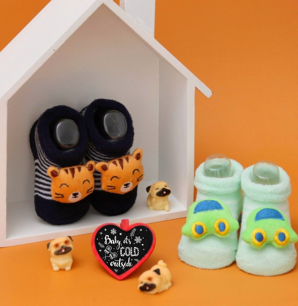 Infant socks with tiger stuffed toys and a car design, displayed in a homey setting.
