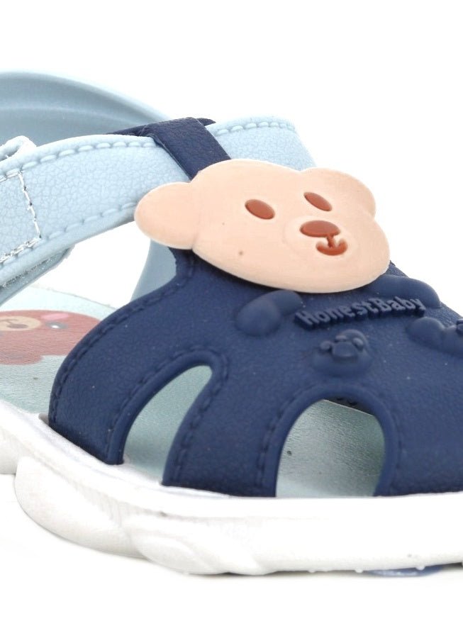 Close-up of the bear applique on the strap of toddler sandals.