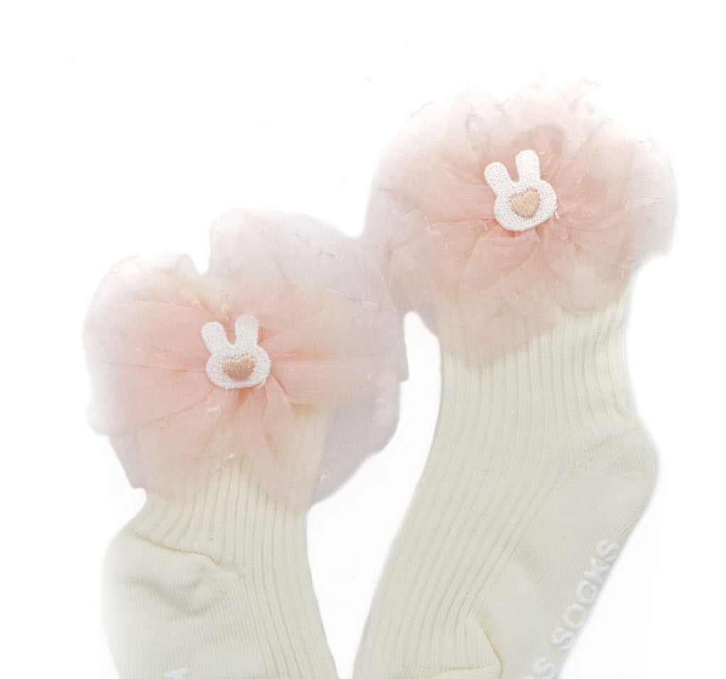 Close-up of the bow detail on peach kids' socks with a sparkly strawberry accent