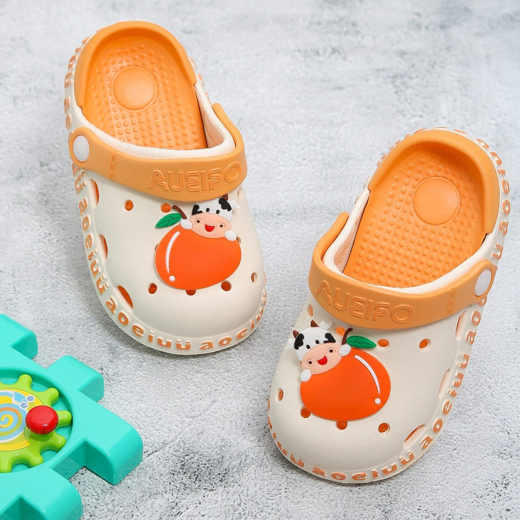 Beige kids' garden sandals with a cute cow and orange fruit design and a comfy footbed.