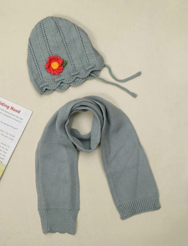 Grey knitted beanie with flower applique for girls on display