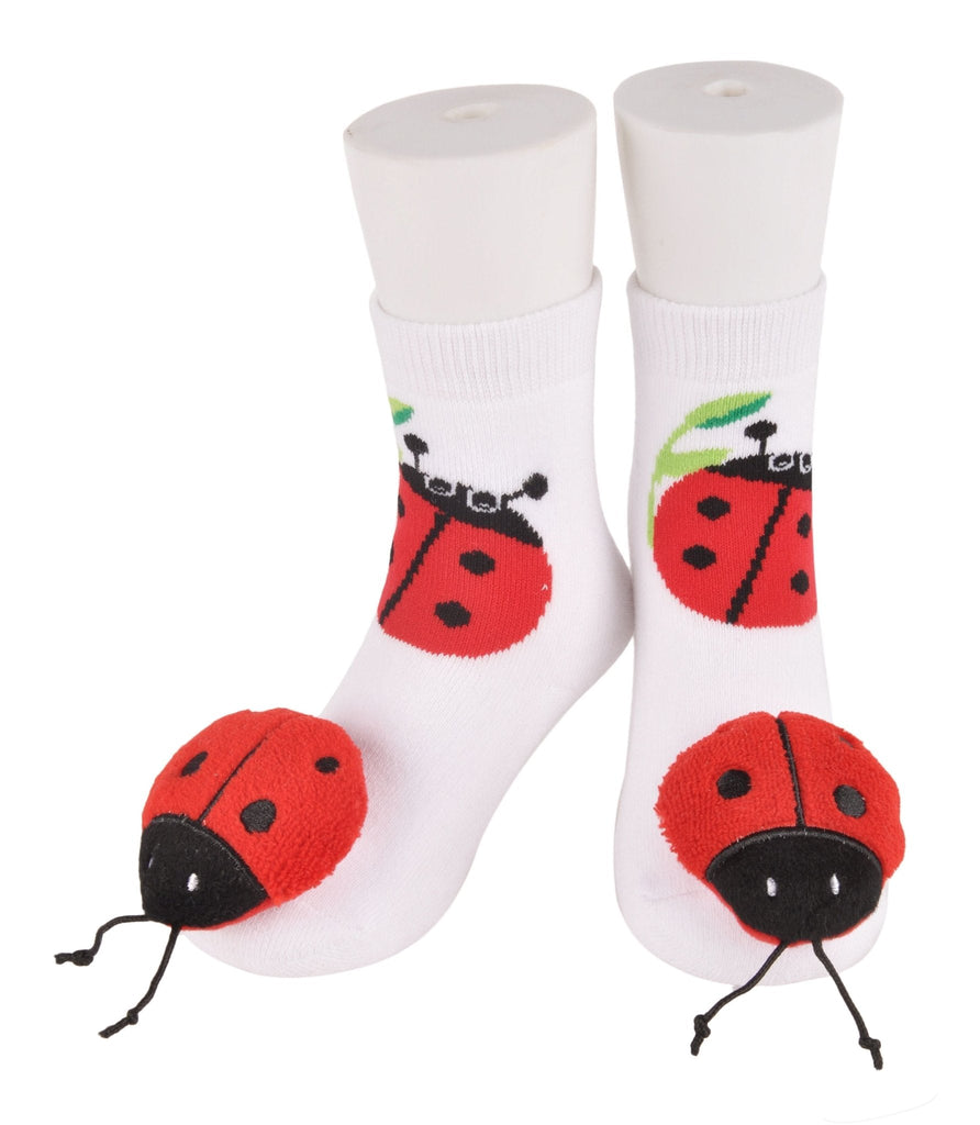 Two pairs of white ladybug socks for toddlers displayed side by side