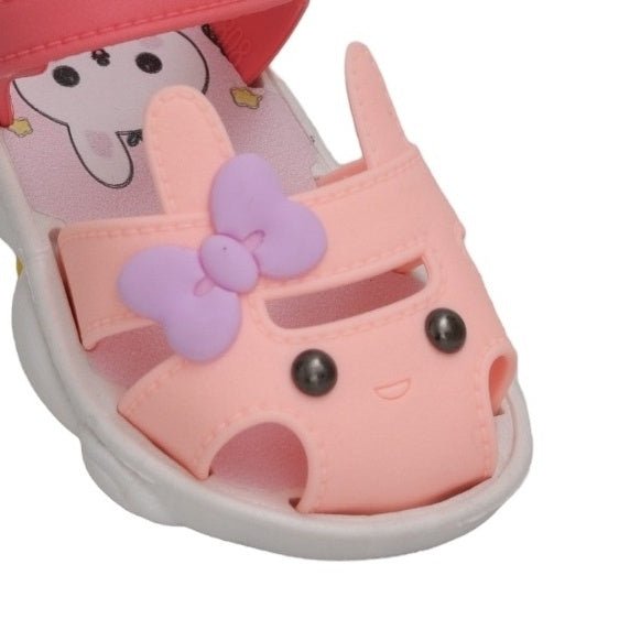Adorable close-up of the bunny face applique on the peach sandal, complete with a charming purple flower.