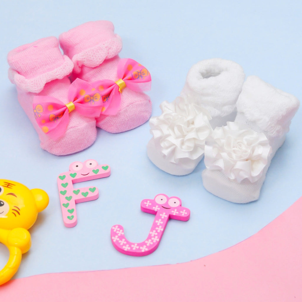 Assorted baby girl socks set with floral and bow accents against a playful background.