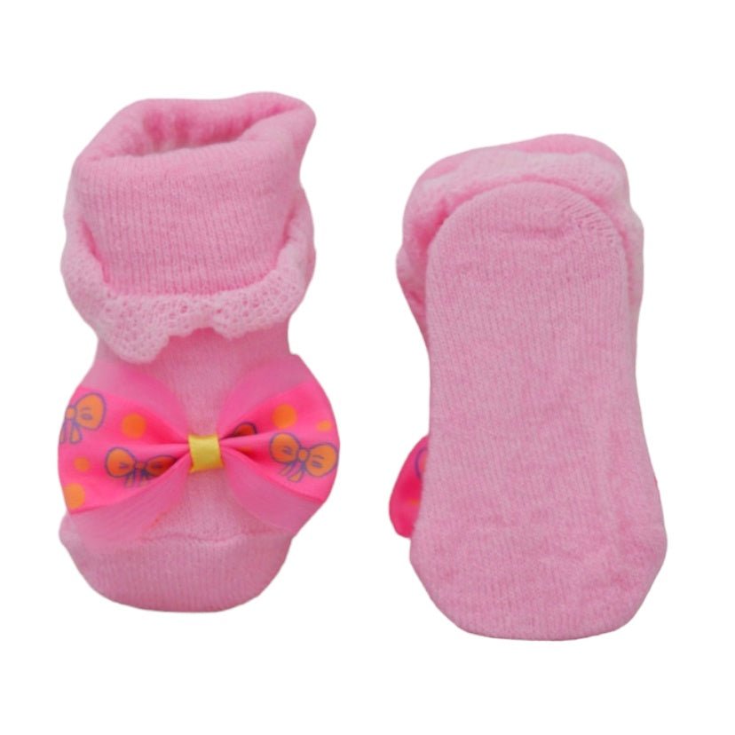 Bottom view of pink baby socks with bow detail, showing a smooth and safe sole.