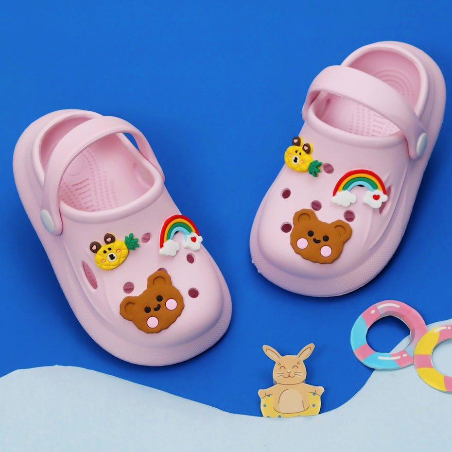 Pair of light pink clogs with colorful animal motifs on a blue background-main image