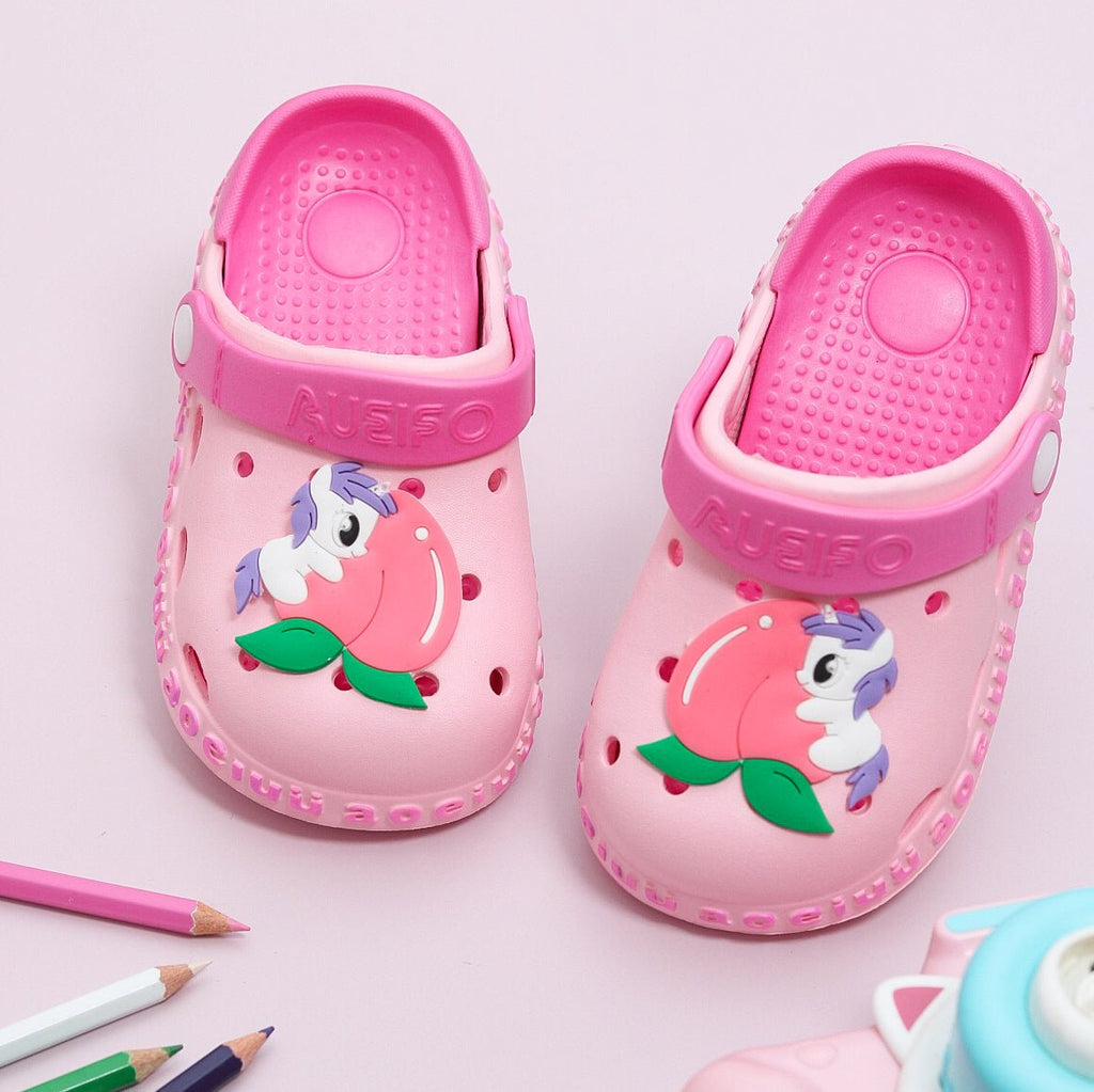 Pink garden clogs for kids with a playful unicorn and peach design on a cushioned base.