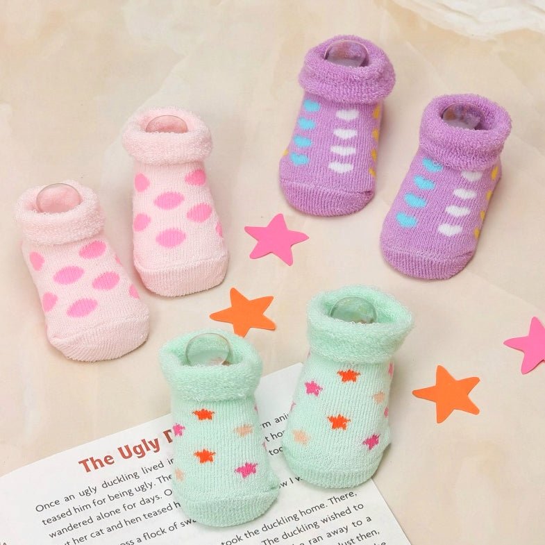 Collection of newborn socks in pastel colors with playful prints and soft elastic cuffs