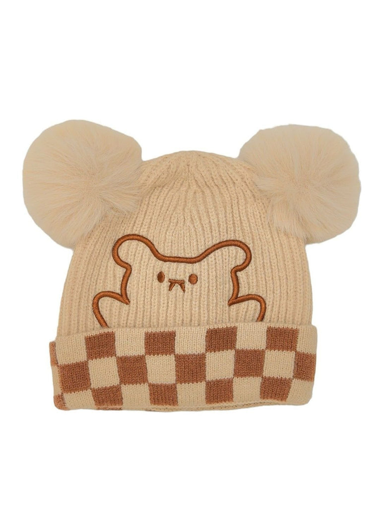 Front view of a beige and brown checkered winter beanie with a cute teddy design and fluffy pom-poms for kids