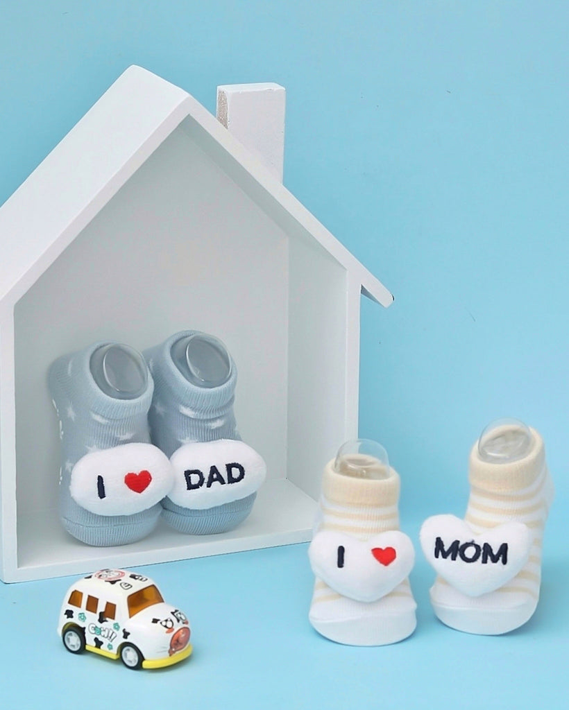 "I Love Dad" blue baby socks in a white house-shaped box.