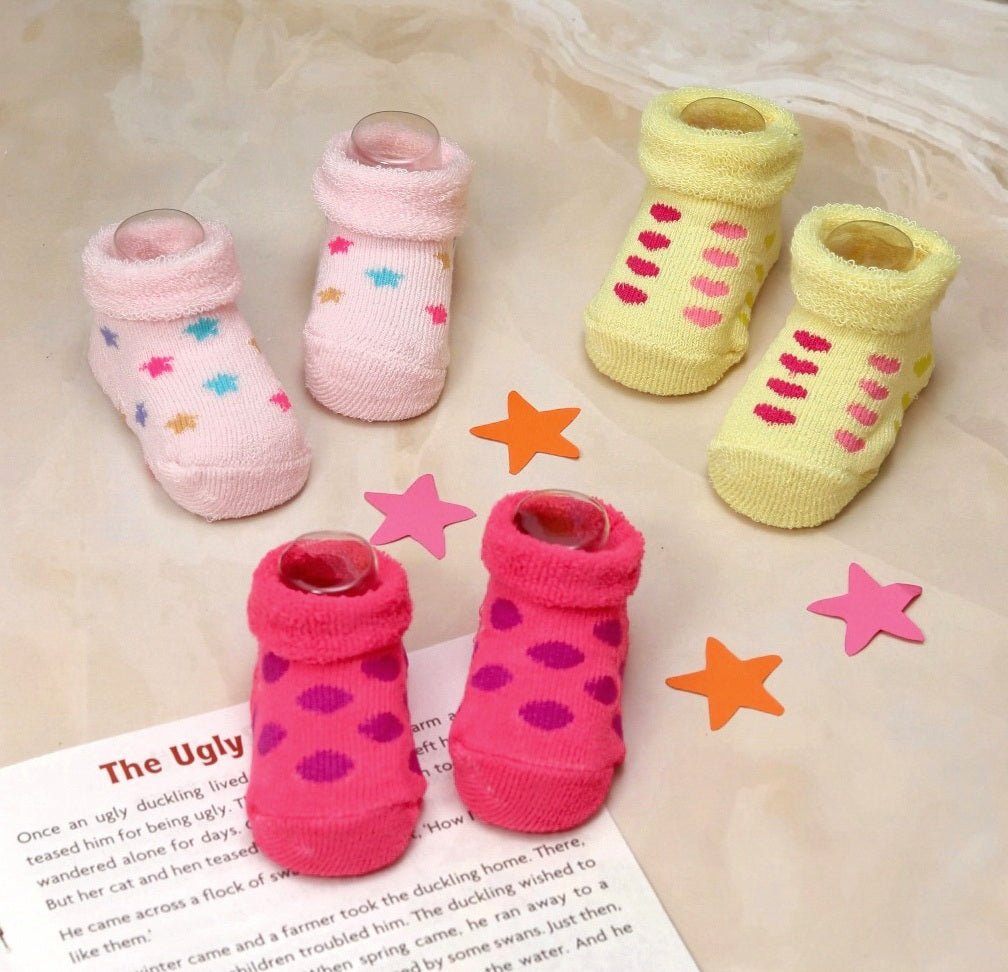 Assorted set of baby socks in pink, yellow, and fuchsia with star and stripe patterns