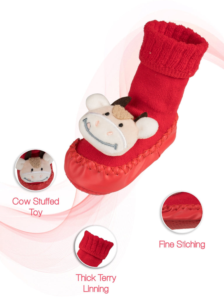 Detailed view of cow stuffed toy on girl's red shoe sock with terry lining and fine stitching.