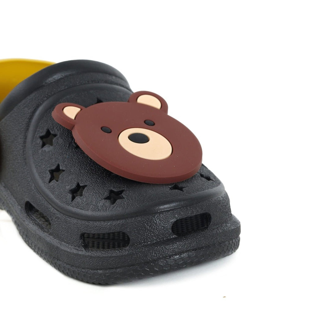 Close-up of the bear face on a black and yellow toddler's clog