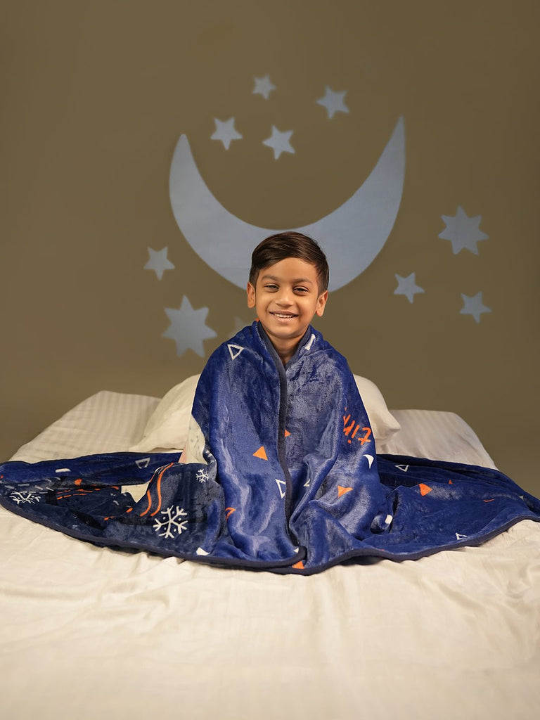 Joyful child sitting in bed with a polar bear blanket, under a crescent moon and starry sky.