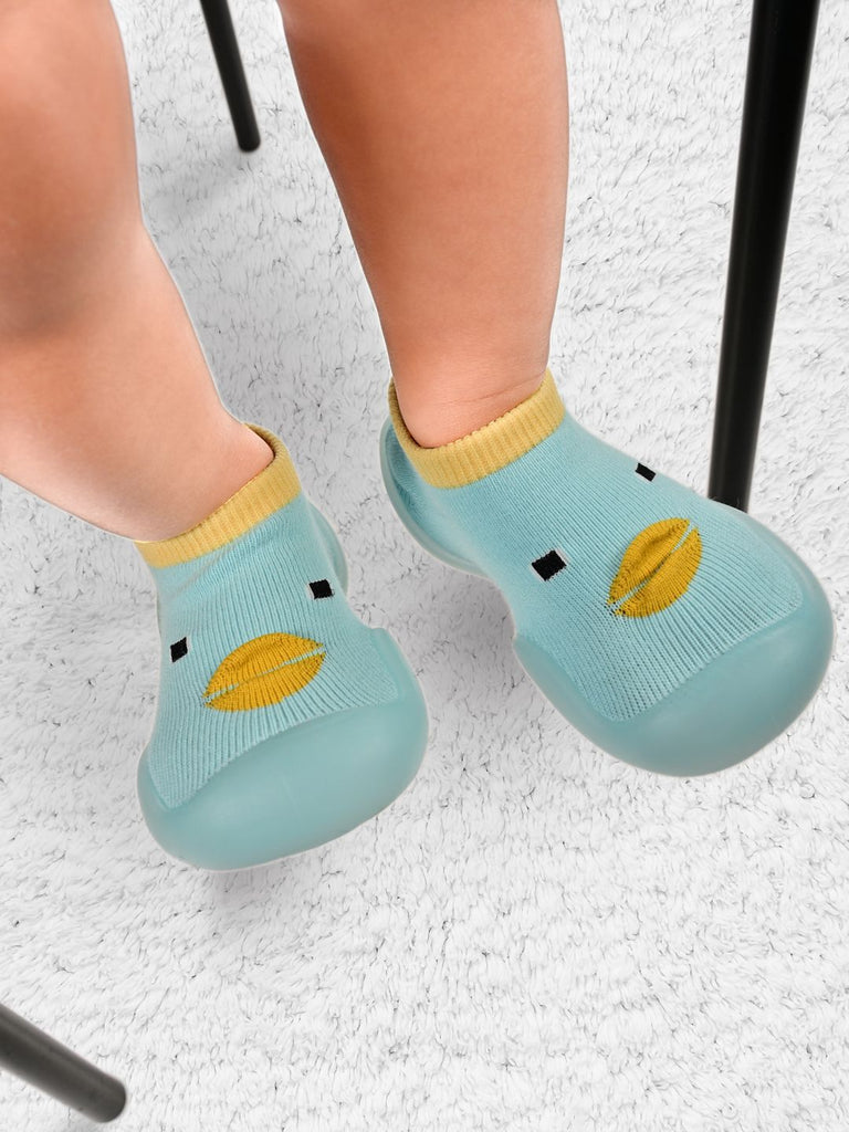 Toddler's feet in duck-patterned shoe socks with anti-skid soles