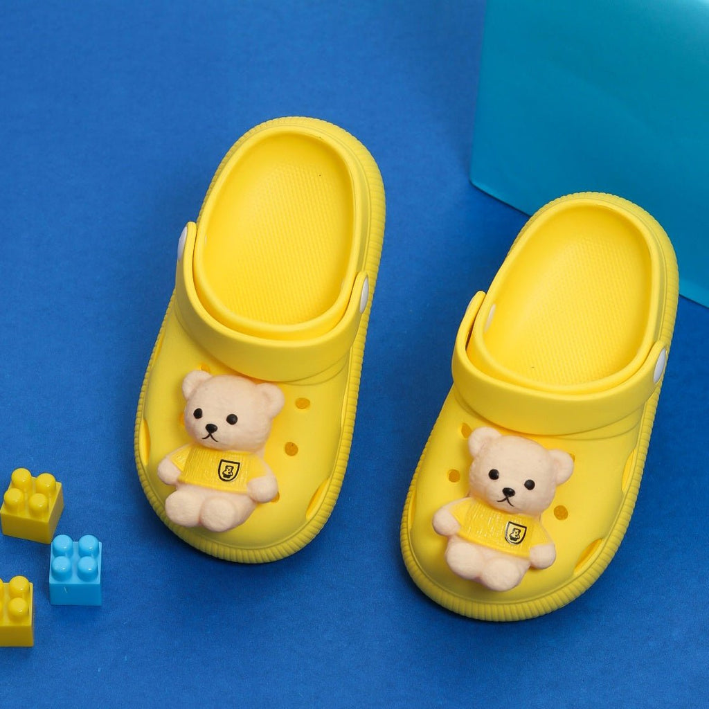 Cheerful yellow clogs for boys with a cute teddy bear applique on top and playful logo blocks on the side
