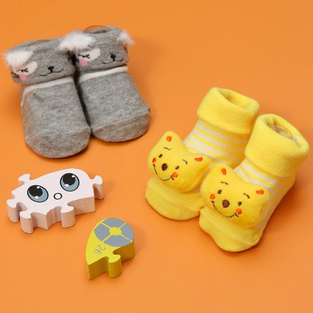 Gray bear-themed baby socks with fluffy ears on orange background