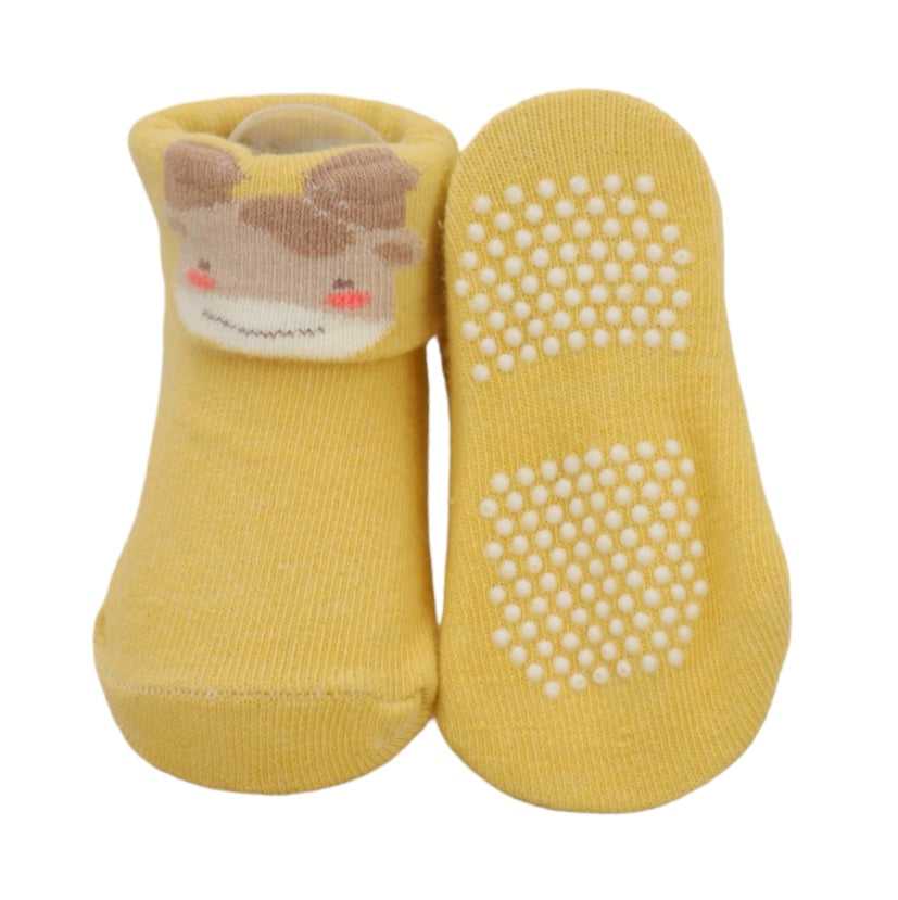 Close-up of baby girl's yellow anti-skid sock with cute fox face design.
