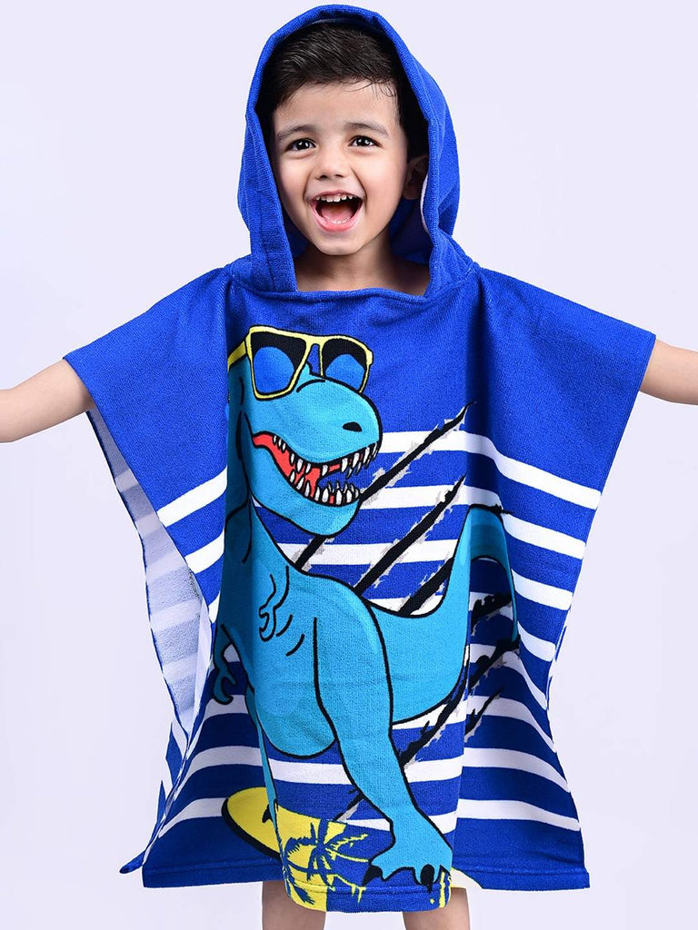 Full pose of a boy with arms spread out wearing the Blue Dino Hooded Poncho Towel by Yellow Bee.