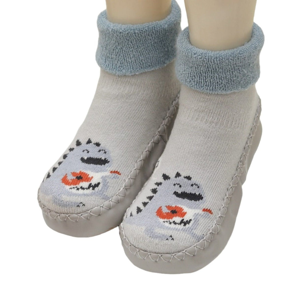 Full view of grey dinosaur-print leather socks for toddlers with soft blue cuffs