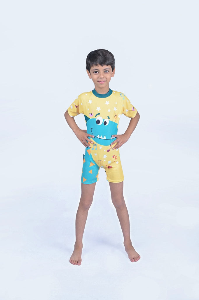 Happy young boy modeling the Dino Print Half Sleeves Swimsuit in yellow
