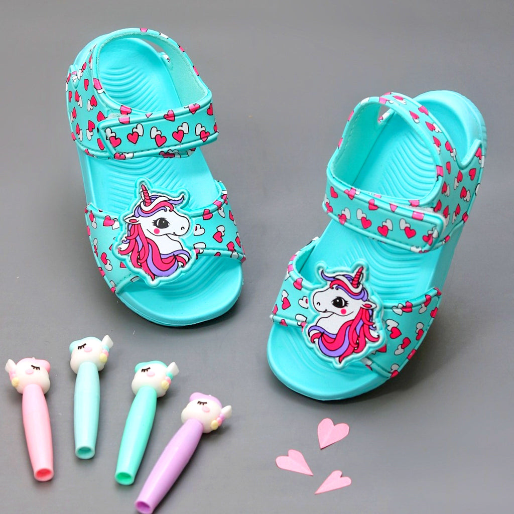 Aqua-colored children's sandals with unicorn and heart strap design on a playful background.
