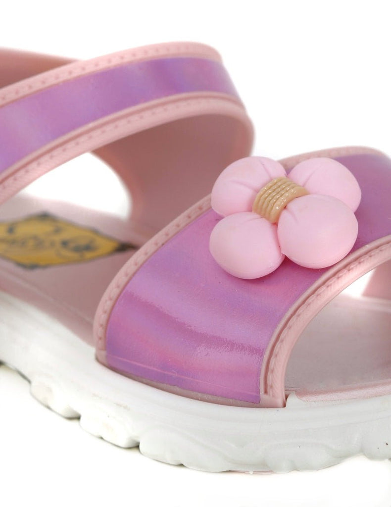 Close-up of a pink flower on holographic strap of a child's sandal.