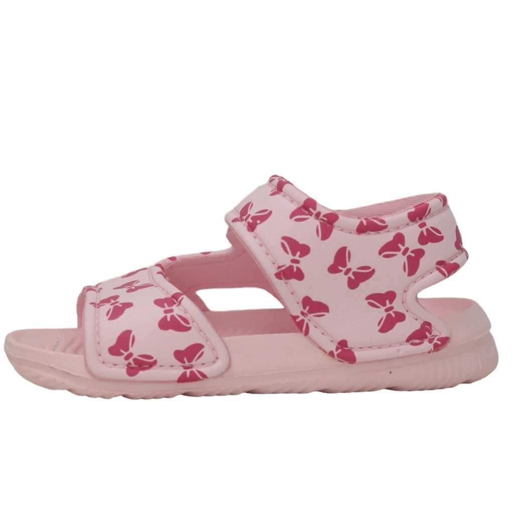 Side view of a pink sandal adorned with a bow pattern for kids