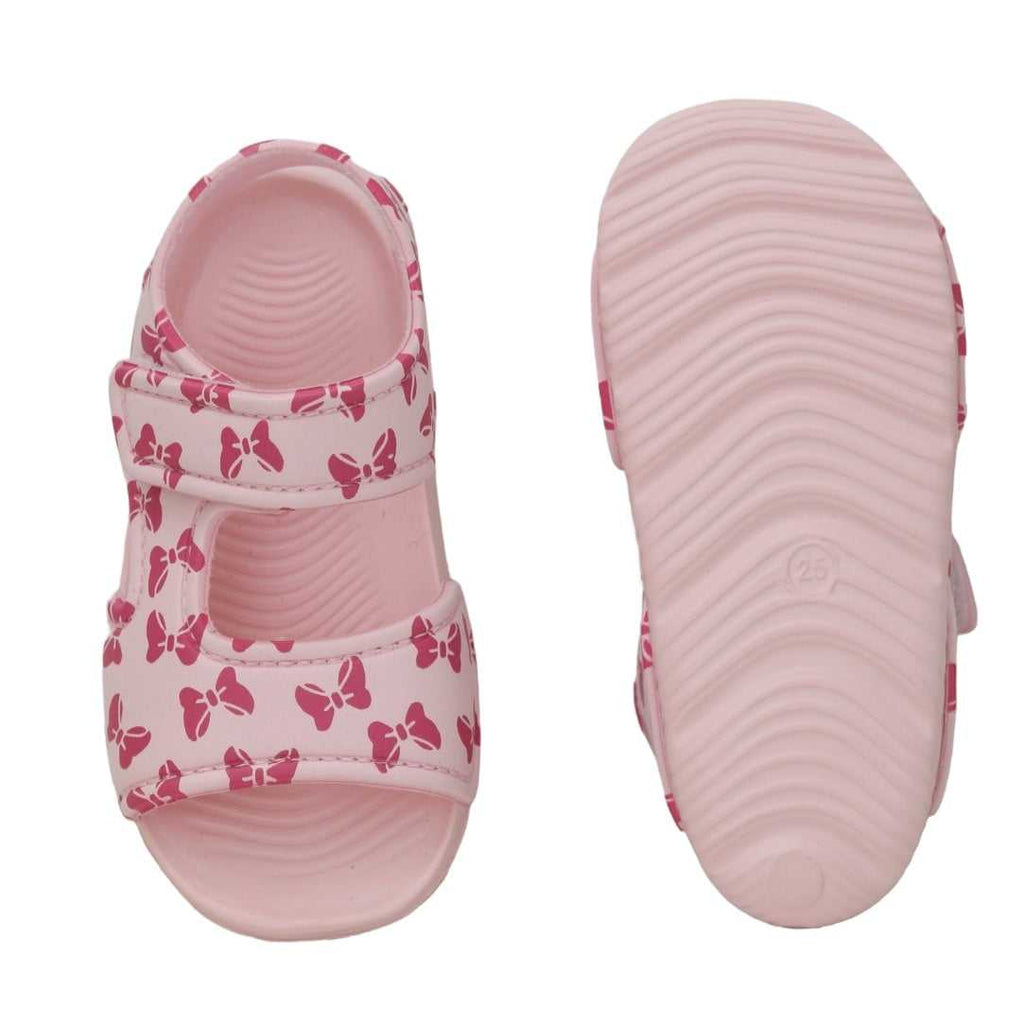 Overhead and sole perspective of children's pink sandals with a bow design.
