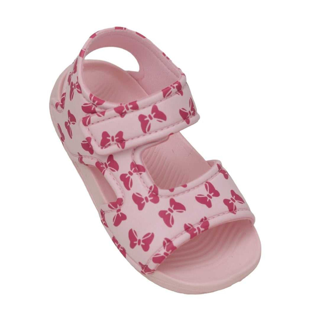 Single pink sandal with bow print angled to show the top and side straps.